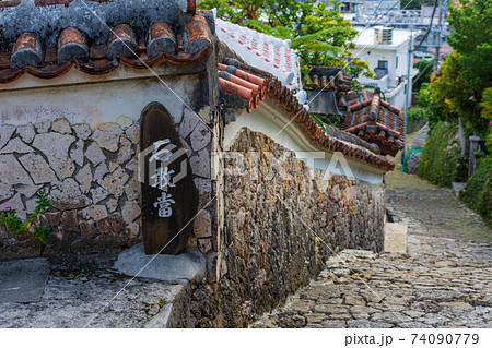 石畳の坂と綺麗な塀沿いを歩く 74090779