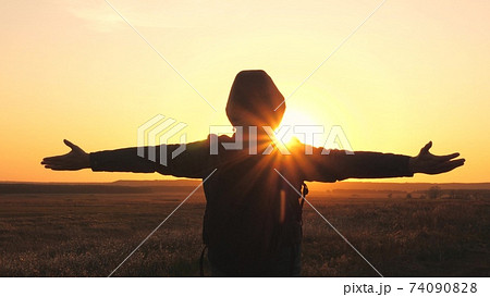 Free and happy male tourist raised his hands up enjoying the inspiring air at sunset in the sky. A person travels alone in the areas of nature. A tourist who has achieved victory and reached the goal Free and happy male tourist raised his hands up enjoying the inspiring air at sunset in the sky. A person travels alone in the areas of nature. A tourist who has achieved victory and reached the goal 74090828
