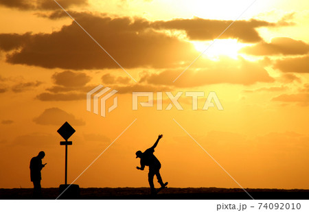 沖縄　夕焼けの中 スケボーを楽しむ少年 74092010