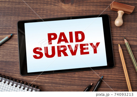 Paid Survey. Business concept. Tablet computer on a wooden office desk 74093213