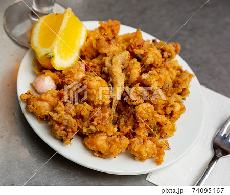 Battered fried baby squid with lemon Battered fried baby squid with lemon 74095467
