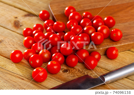 Fresh organic cherry tomatoes on wooden table Fresh organic cherry tomatoes on wooden table 74096138