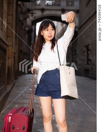 Pretty chinese female tourist making selfie on the background of landmark Pretty chinese female tourist making selfie on the background of landmark 74096416