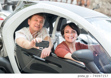 Mature couple driving twizy electric . Mature couple driving twizy electric . 74097157