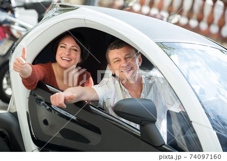 Couple standing near twizy electric 74097160