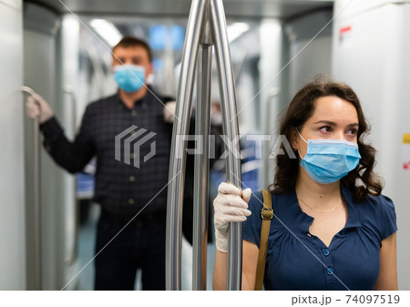 Brunette in medical mask in subway car Brunette in medical mask in subway car 74097519