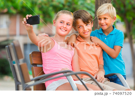 Kids are taking selfie on phone Kids are taking selfie on phone 74097520