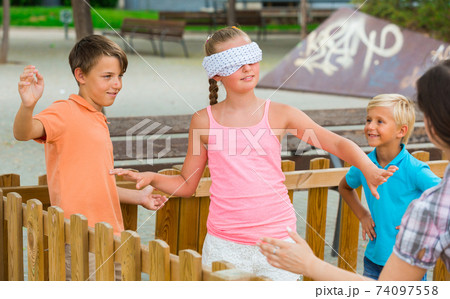 Girls and boys are playing in blindfolders Girls and boys are playing in blindfolders 74097558