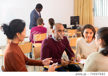 Adult students in cooperation with their school assignment 74097682