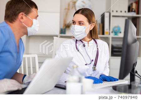Female therapist consulting with male colleague Female therapist consulting with male colleague 74097940