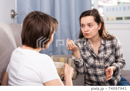 Young female pointing to mistakes to her elderly sister during quarrel Young female pointing to mistakes to her elderly sister during quarrel 74097941