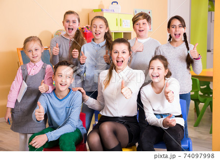 Pupils with teacher giving thumbs up in schoolroom Pupils with teacher giving thumbs up in schoolroom 74097998
