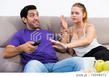 Couple arguing because of TV remote 74098073