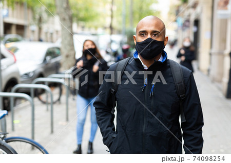 Man in black protective mask on street 74098254