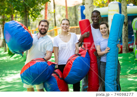 Cheerful people in outdoor inflatable amusement park 74098277