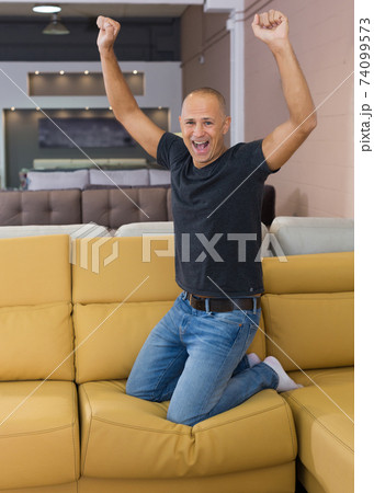 Man jumping on couch in shop 74099573