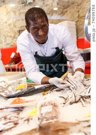 Salesman offering fresh fish Salesman offering fresh fish 74099768