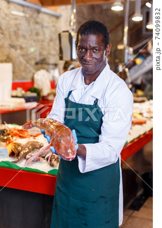 Salesman offering fresh fish 74099832