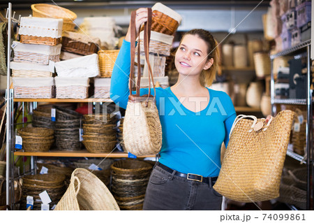 Young woman standing with wicker bag 74099861