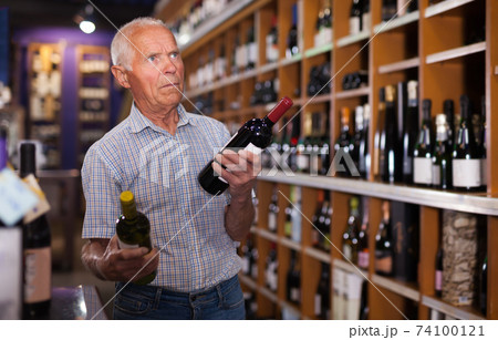 Elderly man visiting winehouse in search of wine Elderly man visiting winehouse in search of wine 74100121