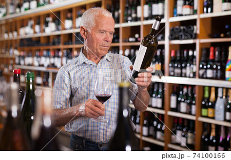 Senior male tasting wines in winery 74100166