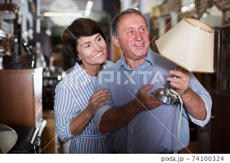 Mature family couple choosing vintage lamp 74100324