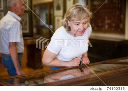 Senior woman looking at exhibit Senior woman looking at exhibit 74100516