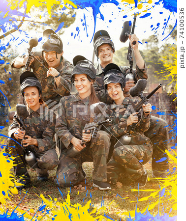 Portrait of paintball players wearing uniform and holding guns r Portrait of paintball players wearing uniform and holding guns r 74100536