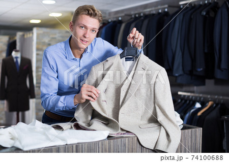 Portrait of man offering business style jacket Portrait of man offering business style jacket 74100688