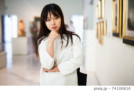 Portrait of chinese young woman near picture collection in the museum 74100810