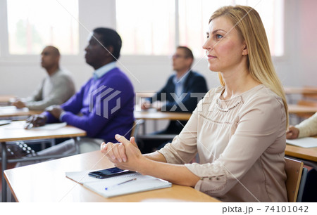 Adult woman studying with colleagues at classroom 74101042