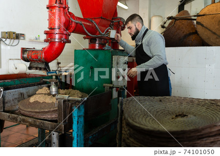 Man applying olive paste to fiber mats Man applying olive paste to fiber mats 74101050