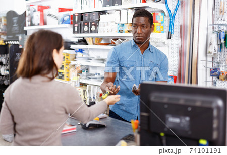 Competent seller consulting young woman about purchase of supplies for household works in store Competent seller consulting young woman about purchase of supplies for household works in store 74101191