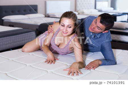 Young couple choosing and lying at matress 74101391