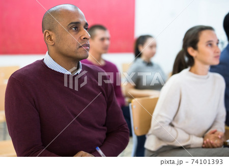 Group of students attentively listening to lecture in classroom Group of students attentively listening to lecture in classroom 74101393
