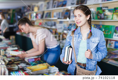 Young girl holding chosen book in hands 74102118