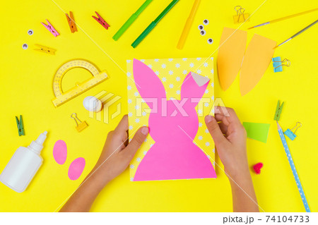 DIY and kids creativity. Step by step instruction: Create an Easter card with bunny and carrot. Childrens handmade Easter craft. 74104733