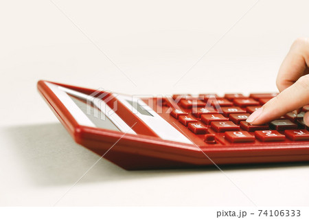 Finance. Female Hand with calculator on financial graphs on desk Finance. Female Hand with calculator on financial graphs on desk 74106333