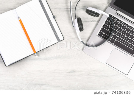 Laptop with headphones on white desk 74106336
