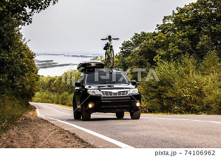Black crossover with a bicycle and roof box at roof rack Black crossover with a bicycle and roof box at roof rack 74106962