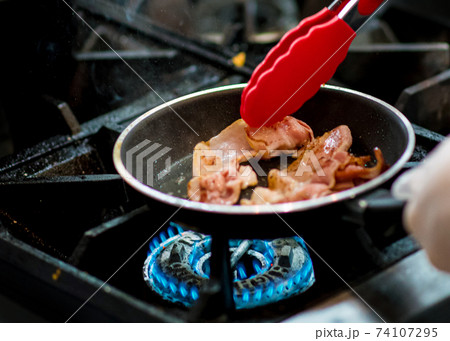 fresh fried bacon in a pan, Chef cooking in the kitchen fresh fried bacon in a pan, Chef cooking in the kitchen 74107295