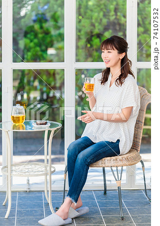 窓辺でお茶を飲んでリラックスする女性 窓辺でお茶を飲んでリラックスする女性 74107532