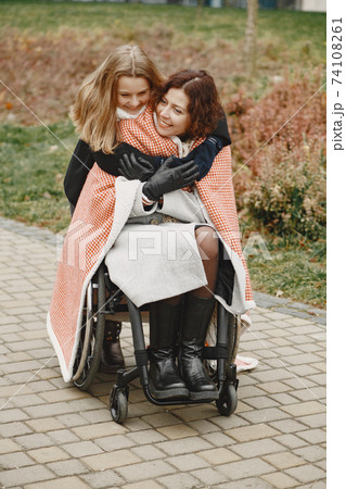 Mother in a wheelchair with hre daughter 74108261
