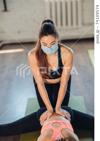 Active sportive woman stretching, young woman helping her Active sportive woman stretching, young woman helping her 74109574