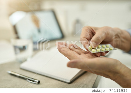 Elderly person taking medication per doctor prescription Elderly person taking medication per doctor prescription 74111935