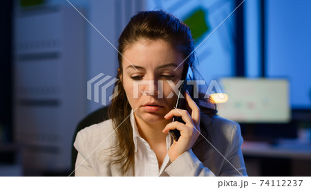 Tired freelancer woman having conversation on phone while working Tired freelancer woman having conversation on phone while working 74112237