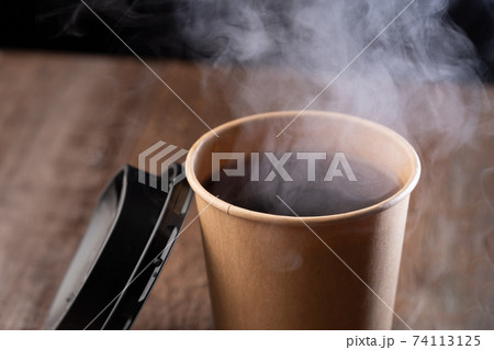 紙コップのコーヒーと湯気の写真素材