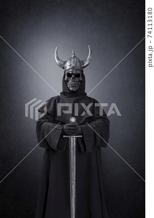 Skeleton warrior with horned helmet and sword in the dark Skeleton warrior with horned helmet and sword in the dark 74113180