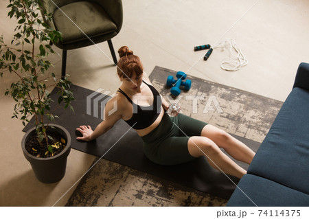 Young woman exercising fitness, aerobic, yoga at home, sporty lifestyle. Getting active during lockdown, quarantine. Home gym. Young woman exercising fitness, aerobic, yoga at home, sporty lifestyle. Getting active during lockdown, quarantine. Home gym. 74114375