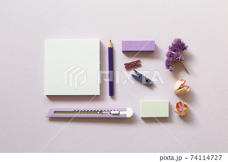Notepad, cutter, colored pencil, clip, eraser on purple background. flat lay, top view, copy space. Work and study place 74114727